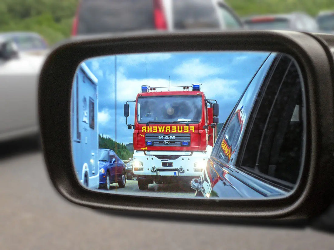 Blick in den Pkw-Außenspiegel: Ein Feuerwehrfahrzeug nähert sich. Foto: Bernd Bast, pixelio.de